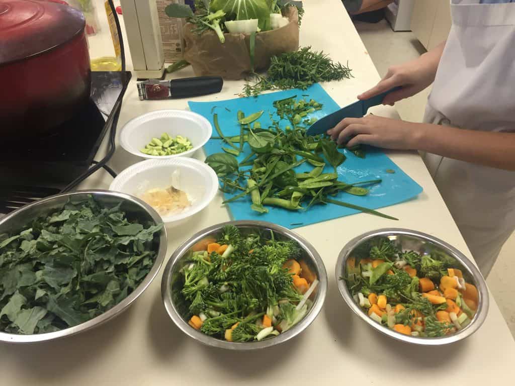 Magnolia Montessori Academy students prepare salad with vegetables from the school garden
