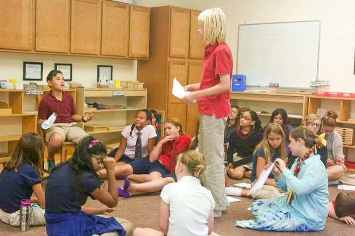 Student stands in front of his class to give a demonstration